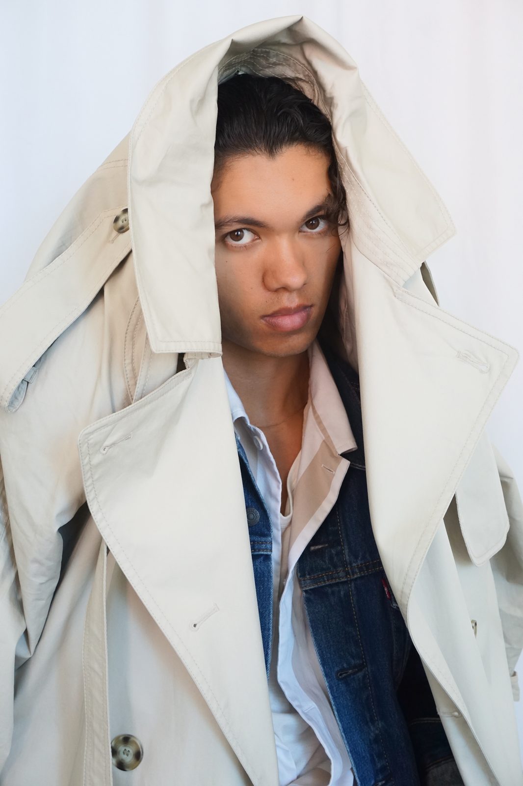 Quentin Lee wrapped in oversized trench coat, dramatic editorial