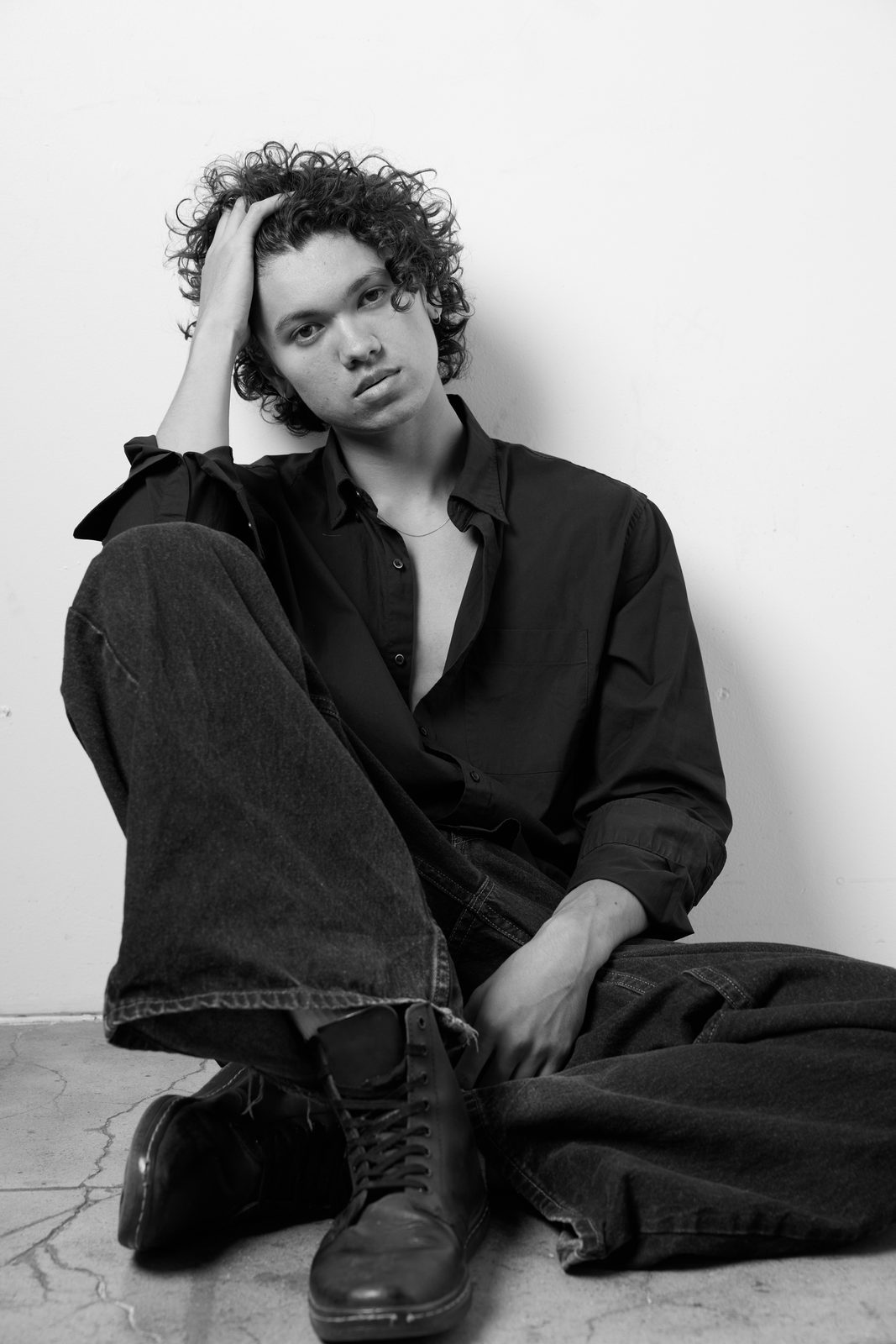 Black and white moody portrait of Quentin Lee seated